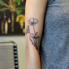 a woman's arm with a flower tattoo on the left side of her arm