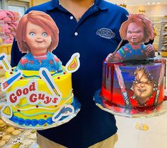 a man holding two cakes decorated with cartoon characters