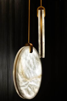 a marble clock hanging from the side of a wall