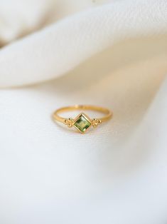 P E R I D O T ∙ R I N G  This ring features a stunning square-cut peridot gemstone at its centre. Crafted with 24k gold vermeil plated over 925 sterling silver for longetivity, this ring radiates luxury and sophistication. The band is adorned with a unique three-dot design, adding a modern twist to its classic elegance.  This ring is also available in Blue Topaz, Garnet, Amethyst, Citrine, Carnelian and Iolite Gemstones. Please write to us for customisations.  * Material: High Quality 24K Gold Vermeil on 925 Sterling Silver - Waterproof, Hypo-Allergenic and Nickel Free * Finish: 24K Gold Vermeil on 925 Sterling Silver | Also available in solid 925 Sterling Silver * Featuring a 4 MM Square Cut Peridot Natural Gemstone * Total Stone Weight: 0.35 Carats H O W ∙ T O ∙ O R D E R Select your rin Luxury Modern Topaz Ring For Gift, Luxury Classic Green Topaz Ring, Luxury Green Amethyst Rings For Gift, Handcrafted Silver Jewelry, August Birthstone, Natural Stone Jewelry, Peridot Ring, Peridot Gemstone, Dot Design