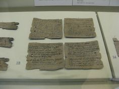 four pieces of ancient writing on display in a museum