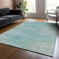 a living room filled with furniture and a large rug on top of a hard wood floor