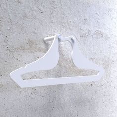 a pair of white clothes hangers on a wall