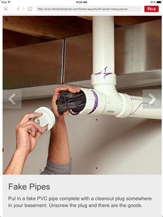 a man is fixing a pipe on the ceiling with his hands and holding something in front of him