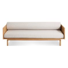 a white couch sitting on top of a wooden frame