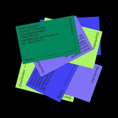 several business cards stacked on top of each other in blue, green, and purple