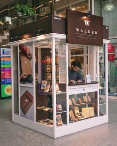 a man standing in front of a display case filled with books