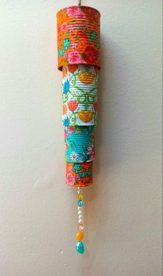 a roll of fabric hanging from the side of a wall next to a beaded necklace