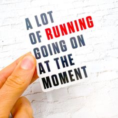 a hand holding a sticker that says a lot of running going on at the moment