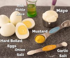 ingredients for deviled eggs laid out on a granite counter with measuring cups and spoons