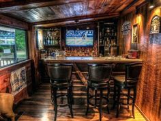 a home bar with stools and a television