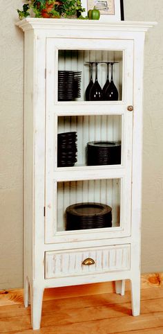 a white cabinet with black plates and wine glasses