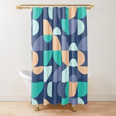 an abstract shower curtain with blue, orange and green circles on it in front of a white bathtub