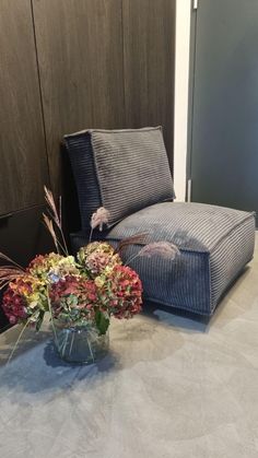 a vase filled with flowers sitting on top of a table next to a couch and chair