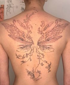 the back of a woman's body with tattoos on it