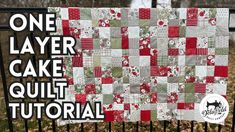 a red and white quilt hanging on a fence with the words one layer cake quilt