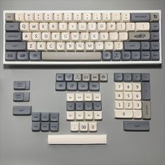 a computer keyboard with several keys and numbers on the back side, all in grey and white