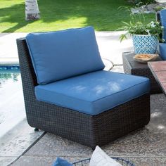 two chairs and a table sitting on top of a patio next to a swimming pool