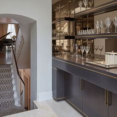 a room filled with lots of glassware on top of a counter next to a piano