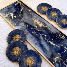 blue and gold trays with flowers sitting on a white towel next to each other