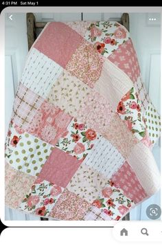 a pink and white patchwork quilt hanging on a door