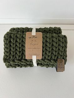 a green crocheted dishcloth with a tag on it