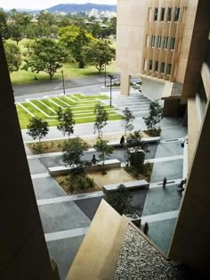 an aerial view of a courtyard with trees and people walking around it in the distance