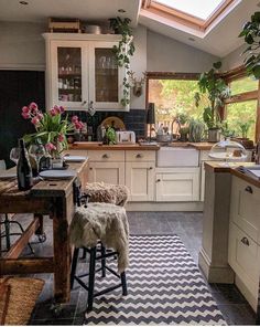 a kitchen filled with lots of counter top space and wooden furniture under a skylight