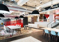 an empty restaurant with tables and chairs in the center, surrounded by hanging light fixtures