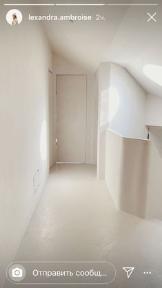 an empty room with white walls and floors is seen on the phone screen in this image