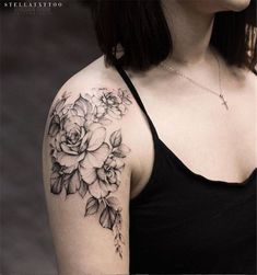 a woman wearing a black tank top has a flower tattoo on her left upper arm