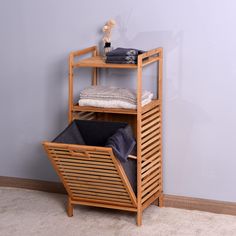 a wooden shelving unit with folded towels and blankets on it's sides, against a blue wall