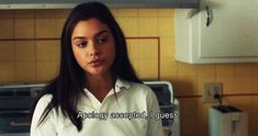 a woman in a white shirt standing in a kitchen