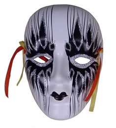 a white mask with black and silver designs on it's face, tied to a red ribbon