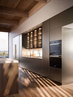 a modern kitchen with stainless steel appliances and wood flooring, overlooking the cityscape