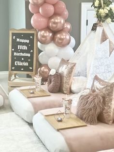 a birthday party setting with balloons, pillows and decorations on the couch in front of it