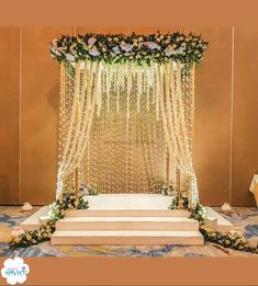 the wedding stage is decorated with flowers and pearls