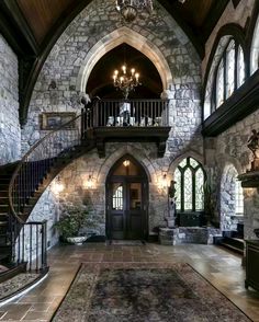 a large stone building with stairs and chandelier in the entryway to it