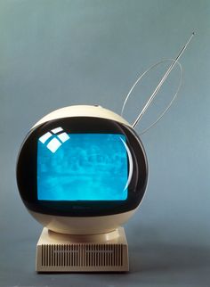 an old fashioned computer with a blue screen on it's face and two wires sticking out of the monitor