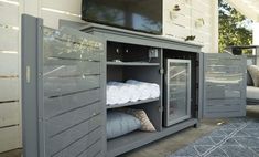 an outdoor entertainment center with towels and pillows on the outside wall, next to a couch