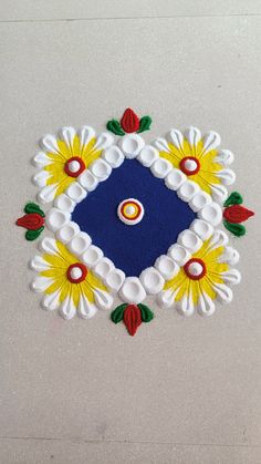 a blue and yellow square with white flowers on the bottom is surrounded by red, yellow, and green leaves