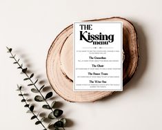 the kissing menu is sitting on top of a wooden slice