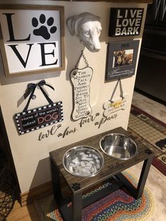 a dog's food bowl is on a table in front of a wall with pictures