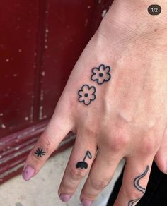 a person with tattoos on their fingers and hand