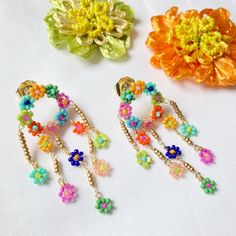 Delicate chandelier earrings made of seed-beaded daisy-covered rings with dangling daisy beaded drops. Earrings measure about 3/4” wide x 2-1/8” long and are lightweight. Plated brass posts. Spring Dangle Jewelry With Dangling Beads, Bohemian Spring Jewelry With Dangling Beads, Bohemian Jewelry With Dangling Beads For Spring, Spring Dangle Beaded Earrings, Small Loop Earrings, Bead Charms Diy, Loop Earrings, Seed Bead Earrings, Diy Projects To Try