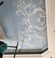 a person painting a ceiling with white paint