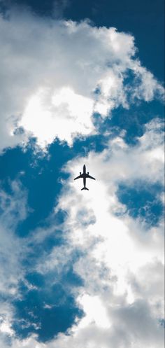 an airplane is flying in the sky with some clouds behind it and blue skies above