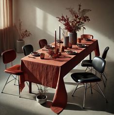 a dining table set with place settings and flowers