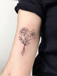 a woman's arm with three flowers on the left side of her arm, and one