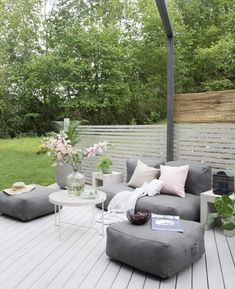 an outdoor living area with grey furniture and flowers